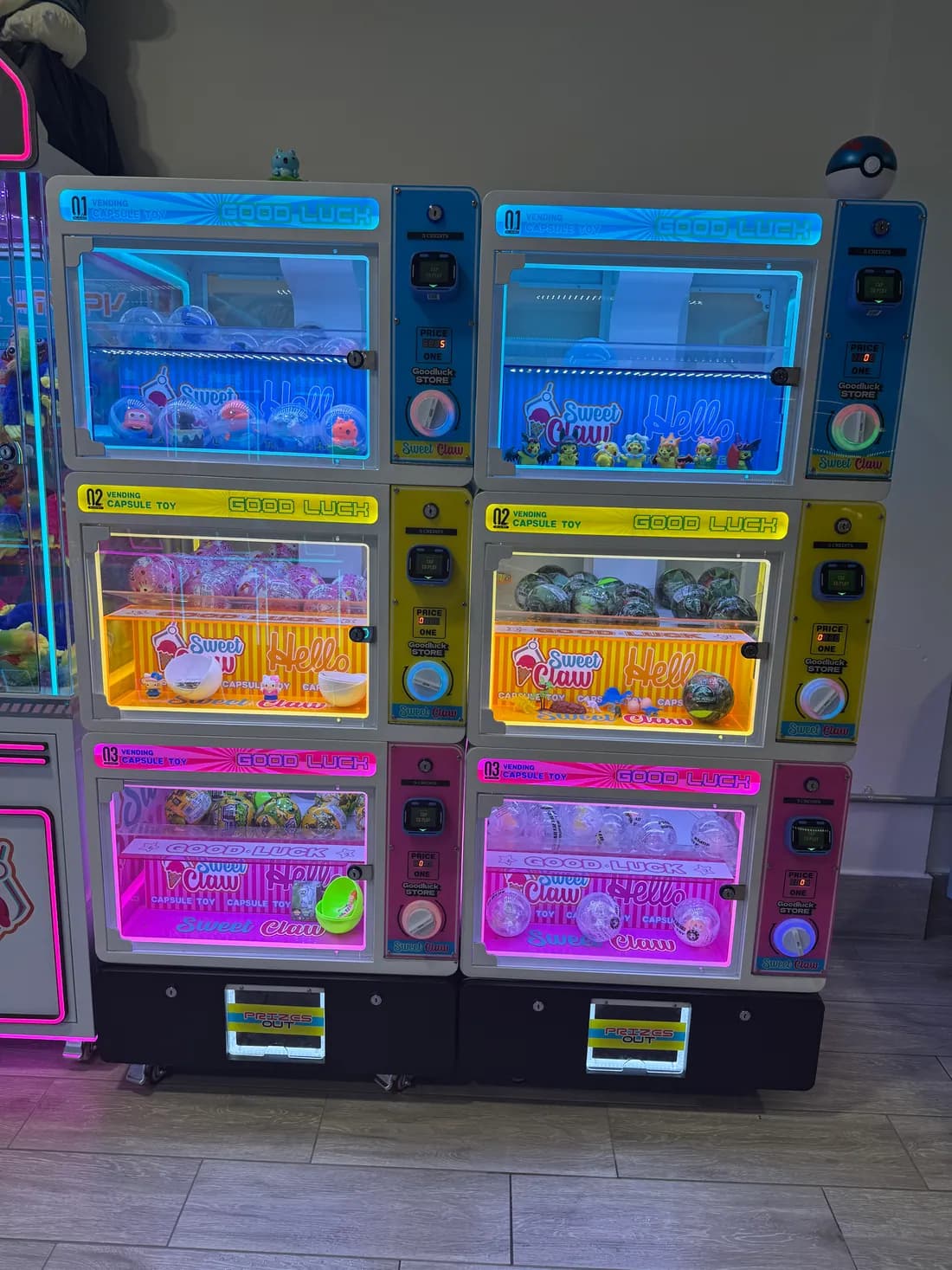 Stacked capsule toy vending machines in blue, yellow and pink