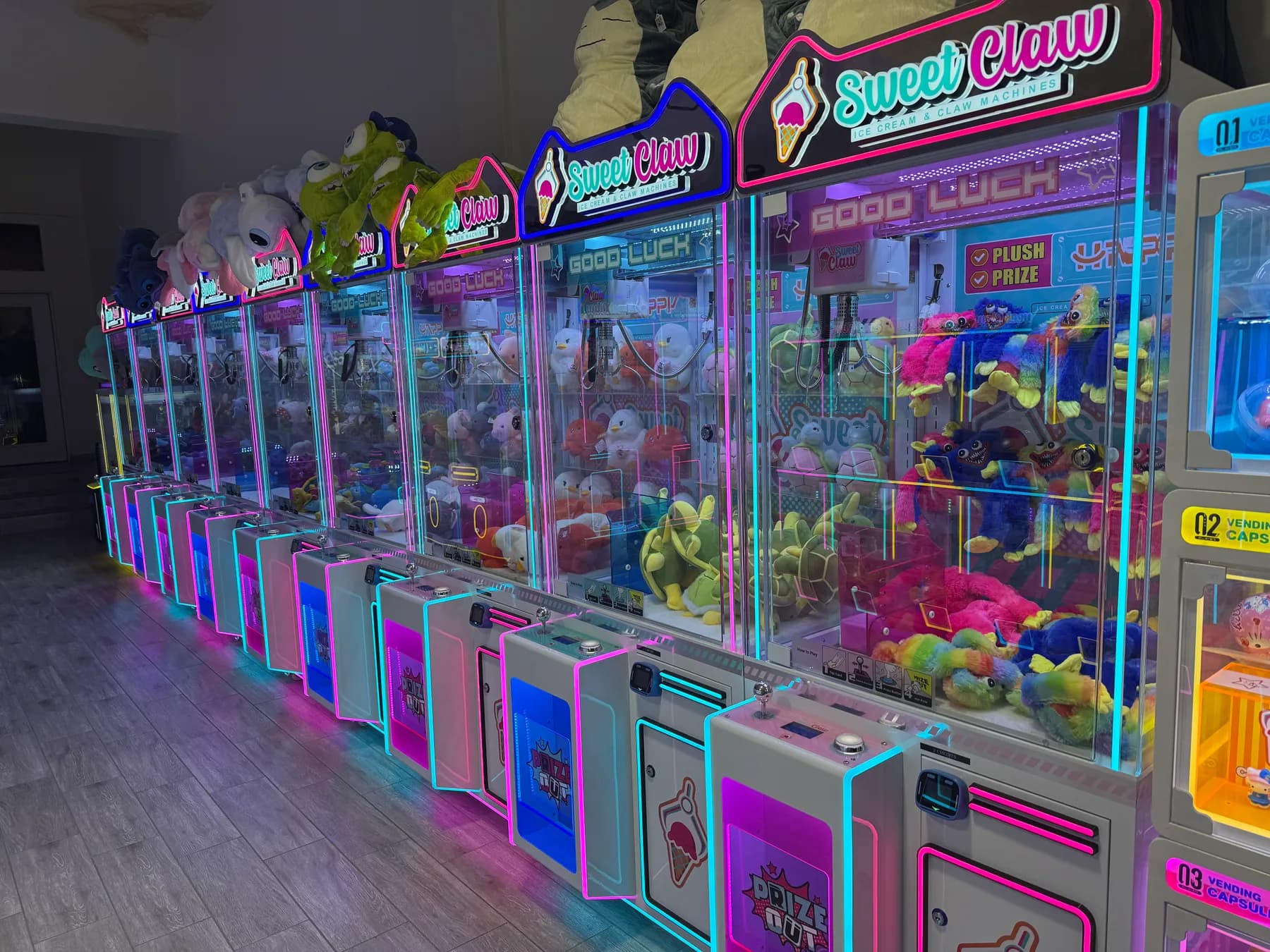 A long row of lit claw machines packed with plush toys