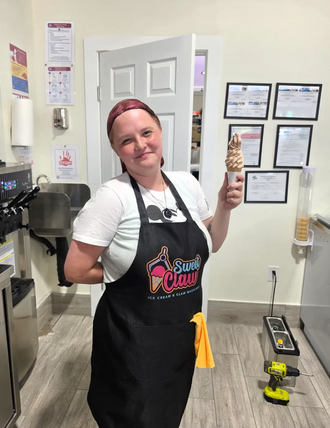 A member of staff holding a freshly made soft serve cone
